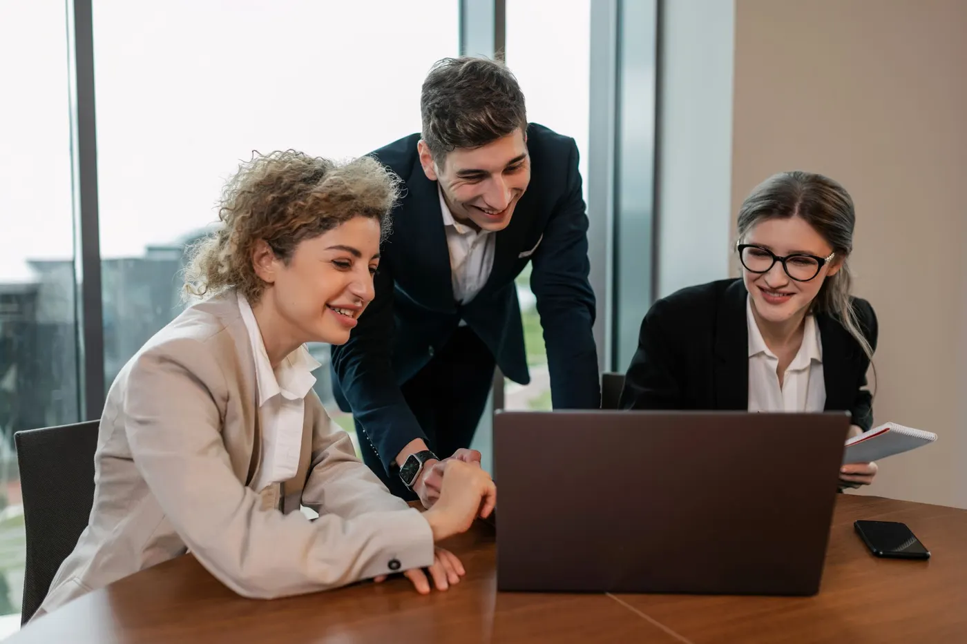 Consultor mostrando um projeto no laptop para duas clientes